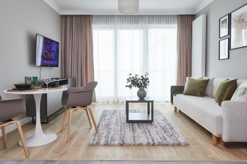 a living room with a couch and a table at Metro Imielin Apartments in Warsaw