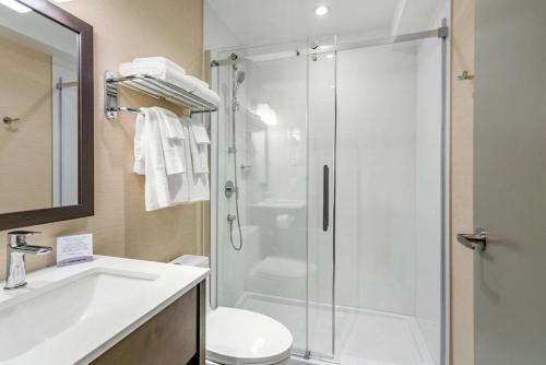 a bathroom with a shower and a toilet and a sink at Quality Inn Centre-Ville in Montréal
