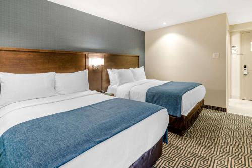 two beds in a hotel room with two at Quality Inn Centre-Ville in Montréal