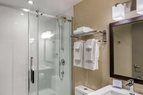 a bathroom with a shower and a toilet and a sink at Quality Inn Centre-Ville in Montreal