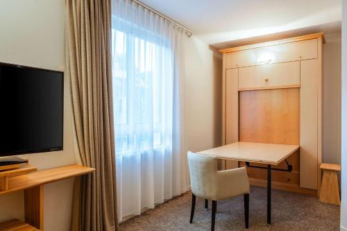 a small room with a table and a window at Quality Hotel Pau Centre Bosquet in Pau