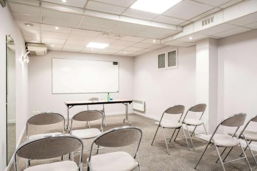 a conference room with chairs and a white screen at Quality Hotel Pau Centre Bosquet in Pau