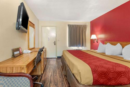 a hotel room with a bed and a flat screen tv at Rodeway Inn Jeffersonville - Washington Court House in Jeffersonville