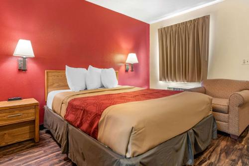 une chambre d'hôtel avec un lit et une chaise dans l'établissement Rodeway Inn, à Jeffersonville