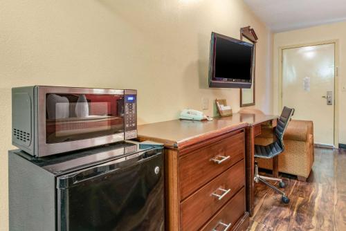a kitchen with a microwave and a desk with a computer at Rodeway Inn Jeffersonville - Washington Court House in Jeffersonville