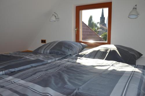 a large bed in a room with a window at Dreiseitenhof Radebeul in Radebeul