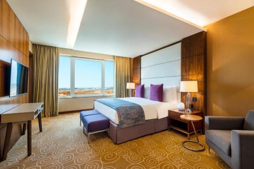 a hotel room with a bed and a couch at Crowne Plaza Muscat OCEC by IHG in Muscat