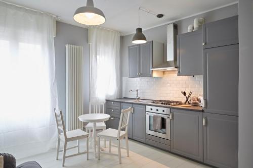 a kitchen with gray cabinets and a table and chairs at Riviera Marco Polo in Mestre