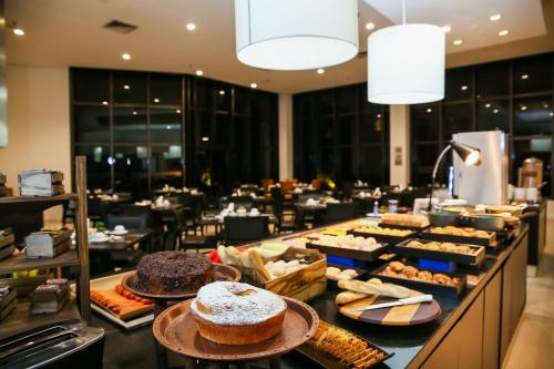 a buffet line with cakes and pastries in a restaurant at Double Tree by Hilton São Paulo Itaim in São Paulo