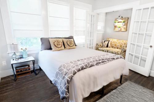 a bedroom with a white bed and a chair at Global Cup Urban Convenience Studio Flat in Dallas