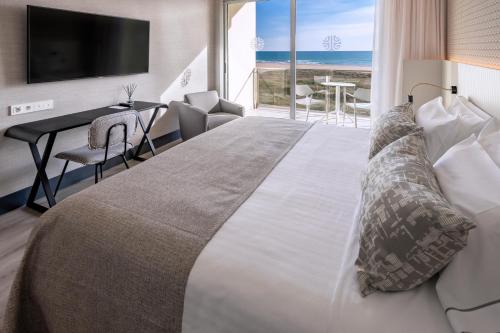 a bedroom with a large bed with a view of the ocean at Bel Air in Castelldefels