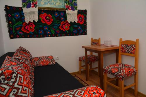 a room with a bed and two chairs and a table at Casa Papițu in Vadu Izei