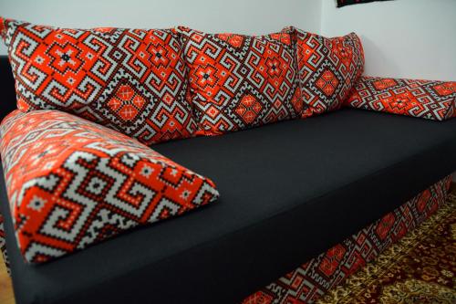 a couch with two pillows on top of it at Casa Papițu in Vadu Izei