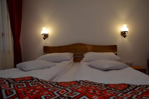 two beds with white sheets and pillows in a bedroom at Casa Papițu in Vadu Izei
