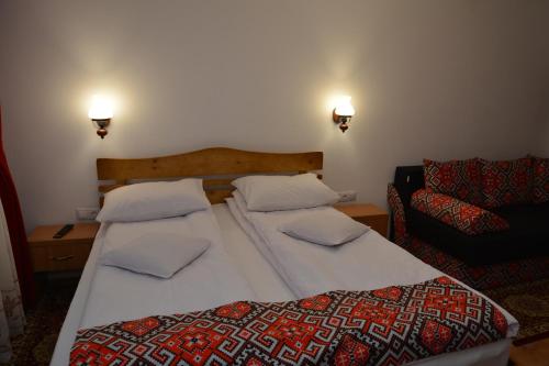 1 dormitorio con 1 cama grande y 1 sofá en Casa Papițu, en Vadu Izei