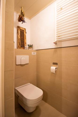 a small bathroom with a toilet and a window at CasaLuca in Hellevoetsluis