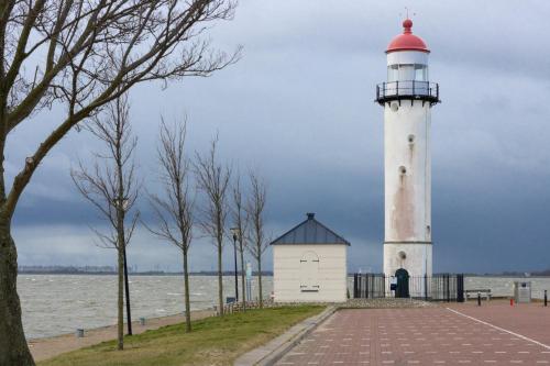 a lighthouse on the shore of a body of water at CasaLuca in Hellevoetsluis