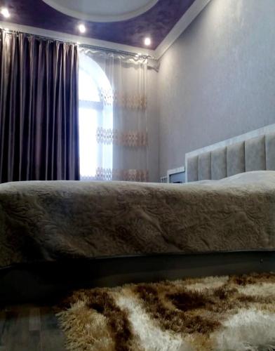 a bedroom with a bed with a window and a rug at Apartments Niagara Gyumri in Gyumri