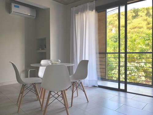 comedor con mesa, sillas y ventana en CERROS del NORTE II Departamentos en San Salvador de Jujuy