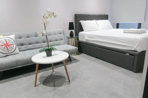 uma sala de estar com uma cama e uma mesa com um sofá em Deluxe Studio & Suite by Recharge em Singapura