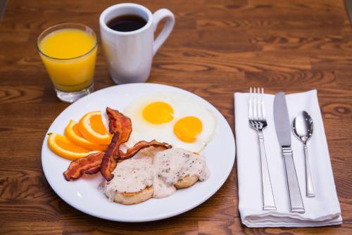 a plate of breakfast food with eggs bacon and orange slices at Holiday Inn and Suites Addison by IHG in Addison