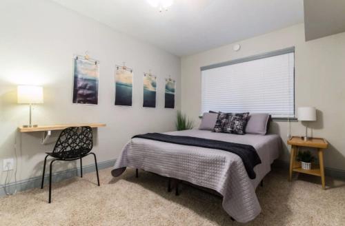 1 dormitorio con cama, escritorio y ventana en Designed to Relax-NO PARTIES ALLOWED en Dallas
