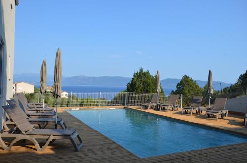 a swimming pool with lounge chairs and umbrellas at Résidence Giovanello in Porto Pollo