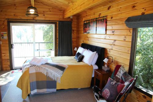 1 dormitorio con 1 cama en una cabaña de madera en Sunset Chalet en Lake Tekapo