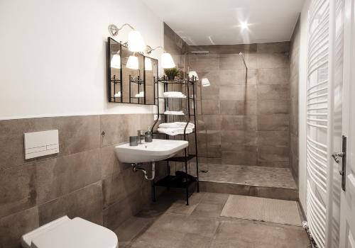 a bathroom with a sink and a toilet and a shower at Villa am Park in Meiningen
