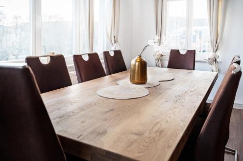 a wooden table with chairs and a lamp on top at Villa am Park in Meiningen
