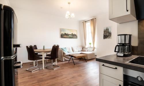 a kitchen and living room with a table and a couch at Villa am Park in Meiningen
