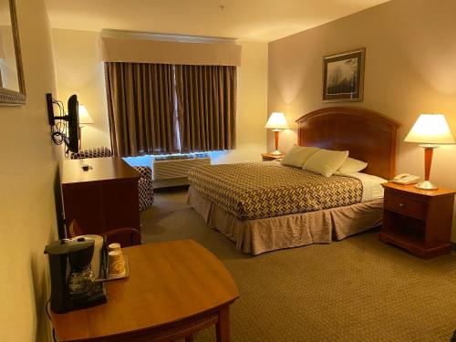 a hotel room with two beds and a table at A Riverside Inn Travelodge by Wyndham in Fairplay