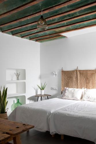 a bedroom with a white bed and a wooden ceiling at Alojamiento rural La Moravieta in Pozoamargo