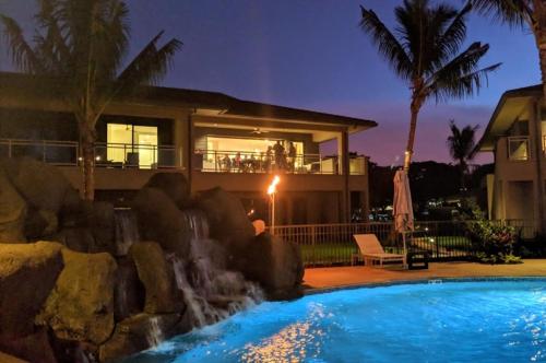 a house with a swimming pool in front of a house at Honua kai - Luana Garden Villa 3C in Kaanapali