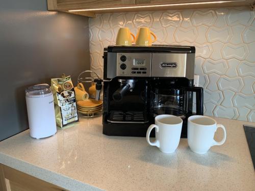 a kitchen counter with two mugs and a coffee maker at Honua kai - Luana Garden Villa 3C in Kaanapali