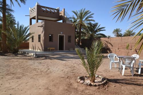 a table and chairs in front of a building at Mhamid Auberge Saharaespace in Mhamid