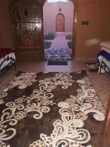 a room with a carpet with a door and a corridor at Mhamid Auberge Saharaespace in Mhamid