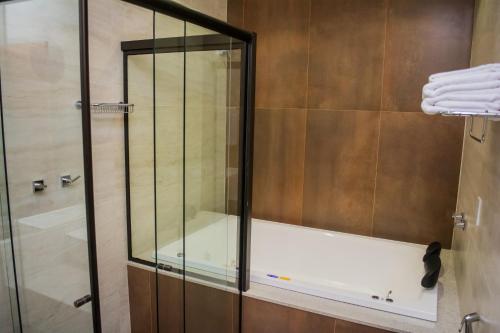 a shower with a glass enclosure in a bathroom at POUSADA ESTÂNCIA in Penedo