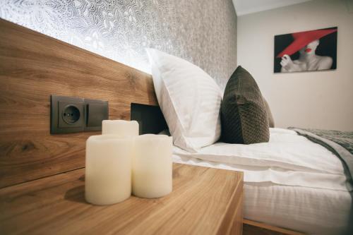 1 dormitorio con 1 cama y 2 velas blancas en una mesa en 4rooms, en Vínnytsia