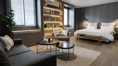 a bedroom with a bed and a living room at Carsson Hotel Downtown Buenos Aires in Buenos Aires