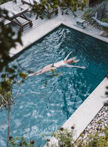 a woman floating in a pool of water at Emily Moon River Lodge in Plettenberg Bay