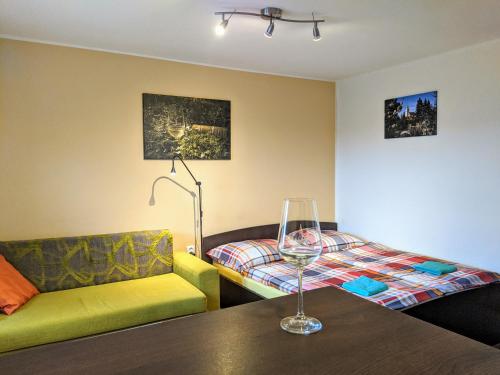 uma sala de estar com um sofá e uma mesa com um copo de vinho em Ubytování ve Vinařství Medek | Medek House & Winery em Uherské Hradiště