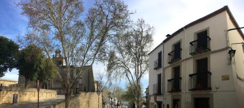 a street with trees and a white building at Balcones con Encanto - vistas al conjunto monumental Patrimonio de la Humanidad in Úbeda