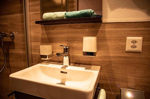 ein Badezimmer mit einem weißen Waschbecken und einem Spiegel in der Unterkunft Landgasthaus Neues Bild, Eggerstanden in Appenzell