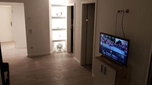 a living room with a flat screen tv on a stand at Ferienwohnung mit Jacuzzi Nähe Flughafen Köln Bonn in Troisdorf