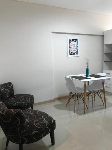 ein Wohnzimmer mit einem Stuhl und einem Tisch in der Unterkunft Departamento Zona Norte in Rosario