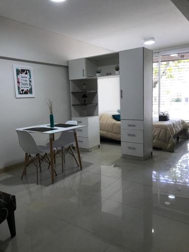ein Wohnzimmer mit einem Tisch und ein Schlafzimmer in der Unterkunft Departamento Zona Norte in Rosario