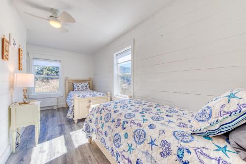 Twin Rocks Beach Retreat في روكواي بيتش: غرفة نوم بسريرين ونوافذ