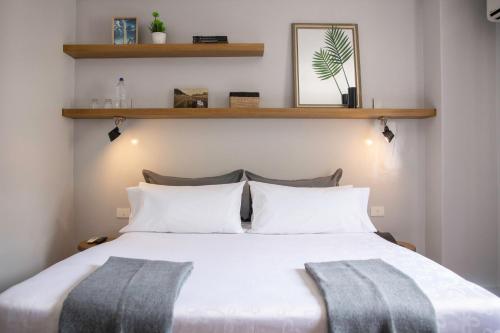 una camera da letto con un grande letto bianco con due cuscini di Carsson Hotel Downtown Buenos Aires a Buenos Aires