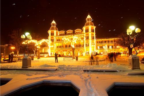 a large building with christmas lights at night at "NATURE erLeben" Appartement & Komfortzimmer in Velden am Wörthersee